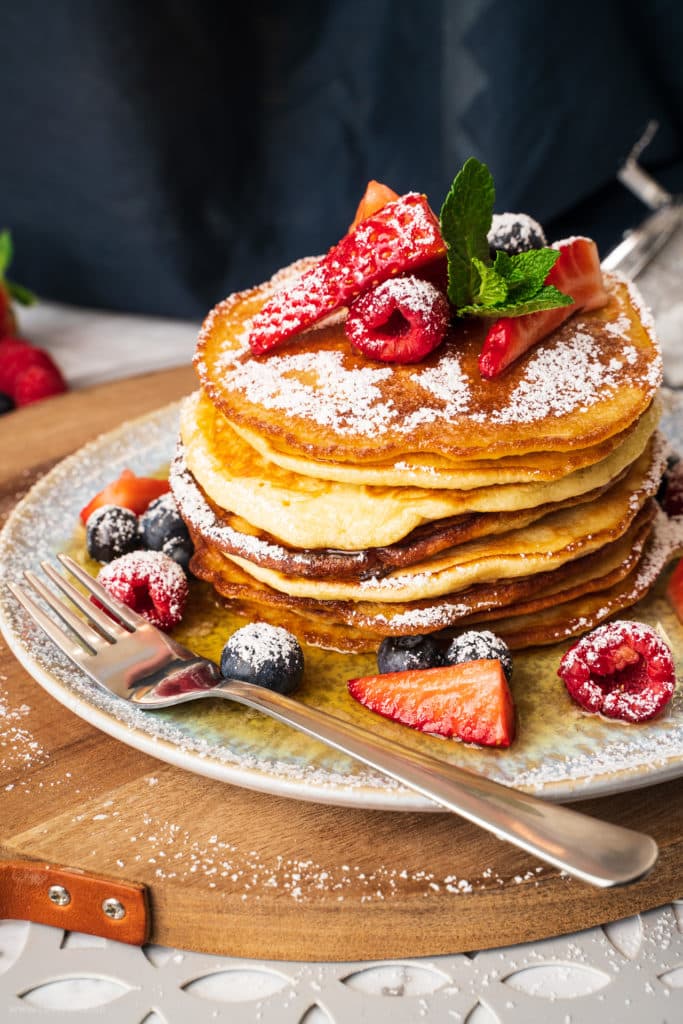Ein Stapel Pancakes mit Ahornsirup & Früchten