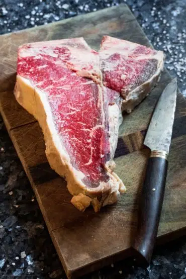 Steak mit einem Messer auf einem Brett