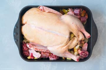 Ganze Ente mit Äpfeln im Bräter